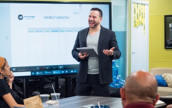 Worker holding an ipad laughing and smiling while presenting 